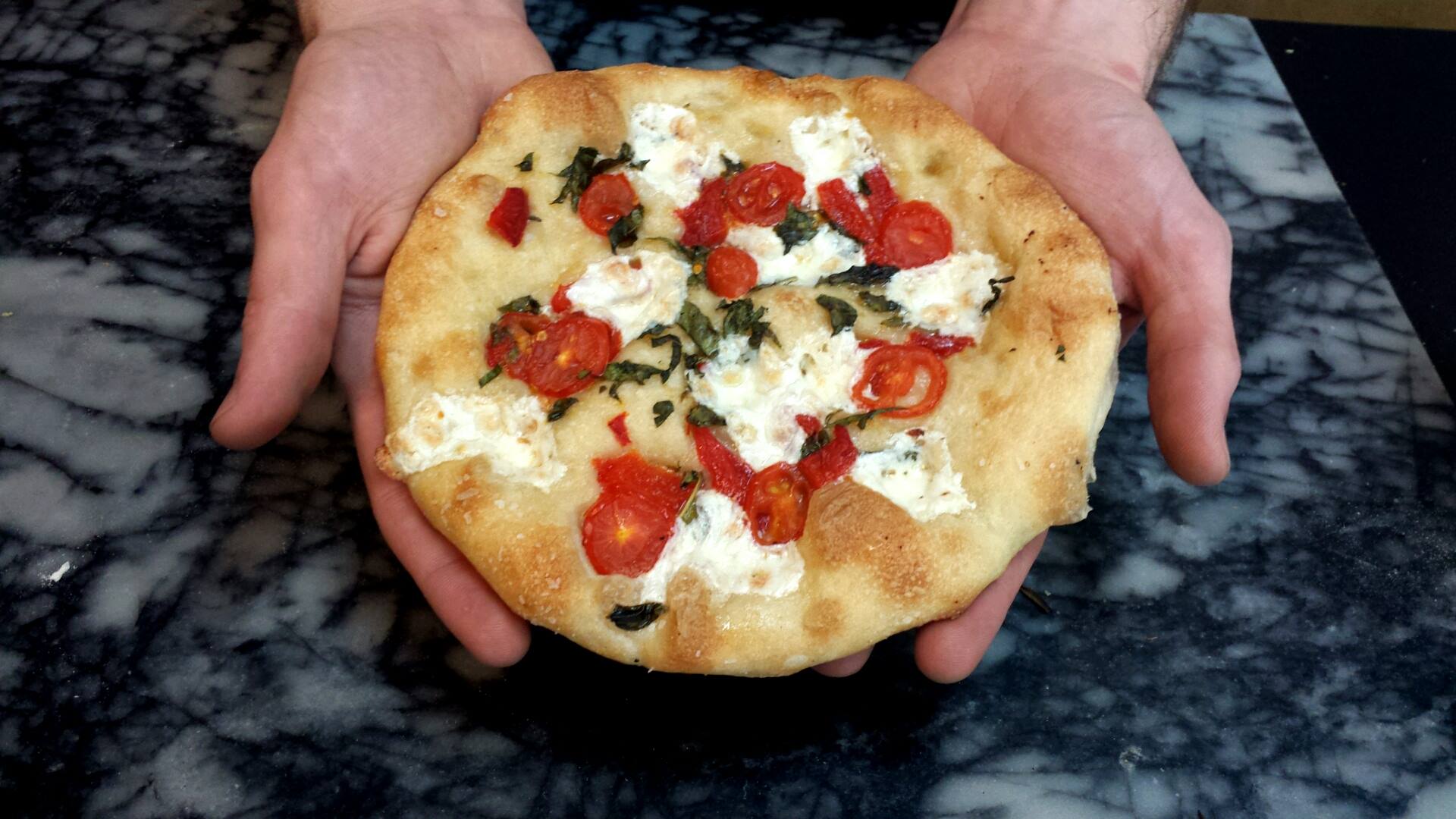 Fresh baked focaccia with tomatoes, basil, and ricotta